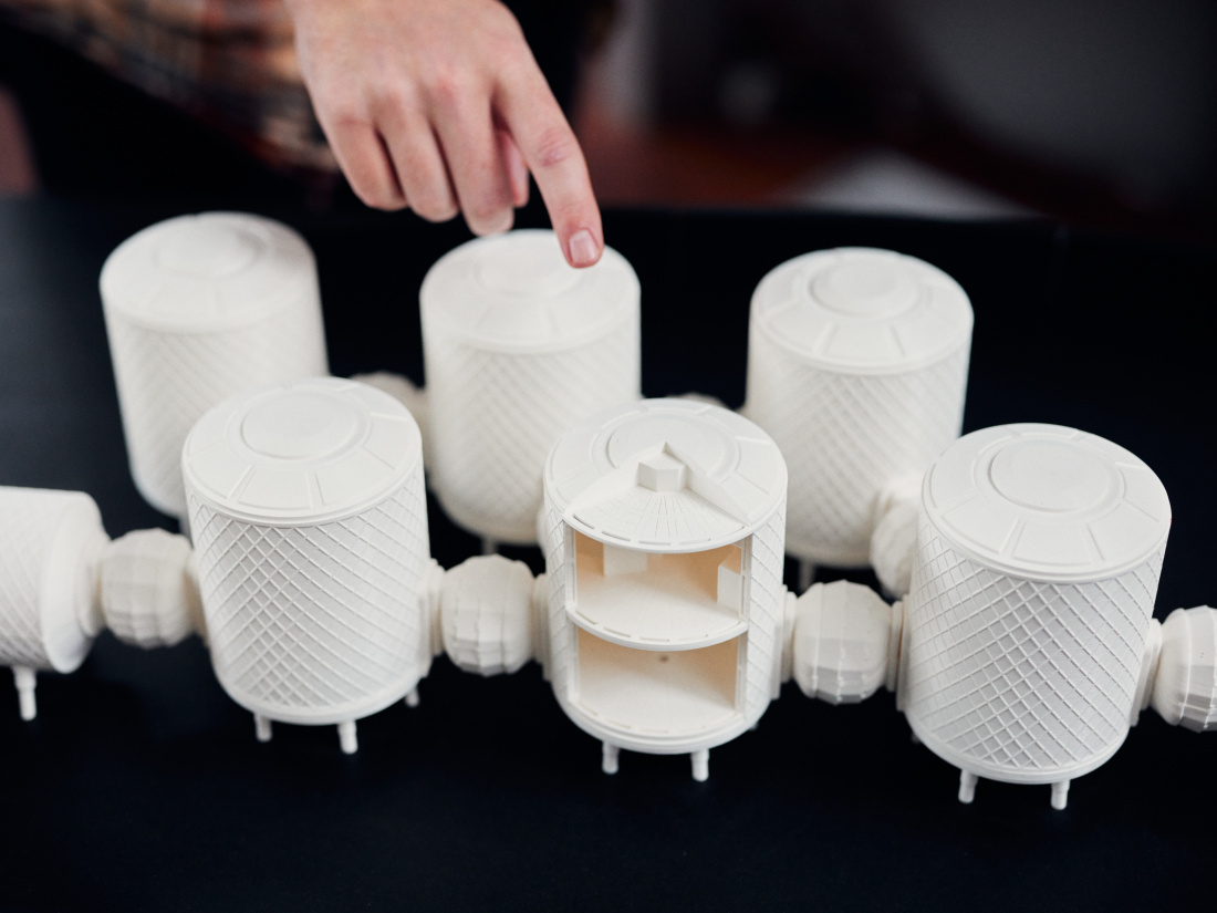 Model of a possible Mars station: six hand-sized white plastic cylinders, one of which is open in cross-section. The cylinders are connected to each other.