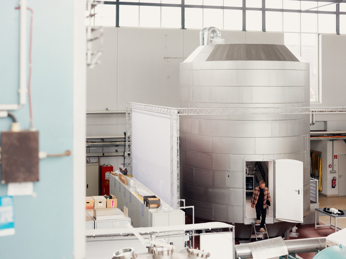 A person climbs out of a model of a Mars laboratory building.