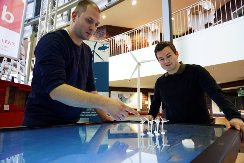 Marco Lewandowski und Stephan Oelker am interaktiven Simulationstisch