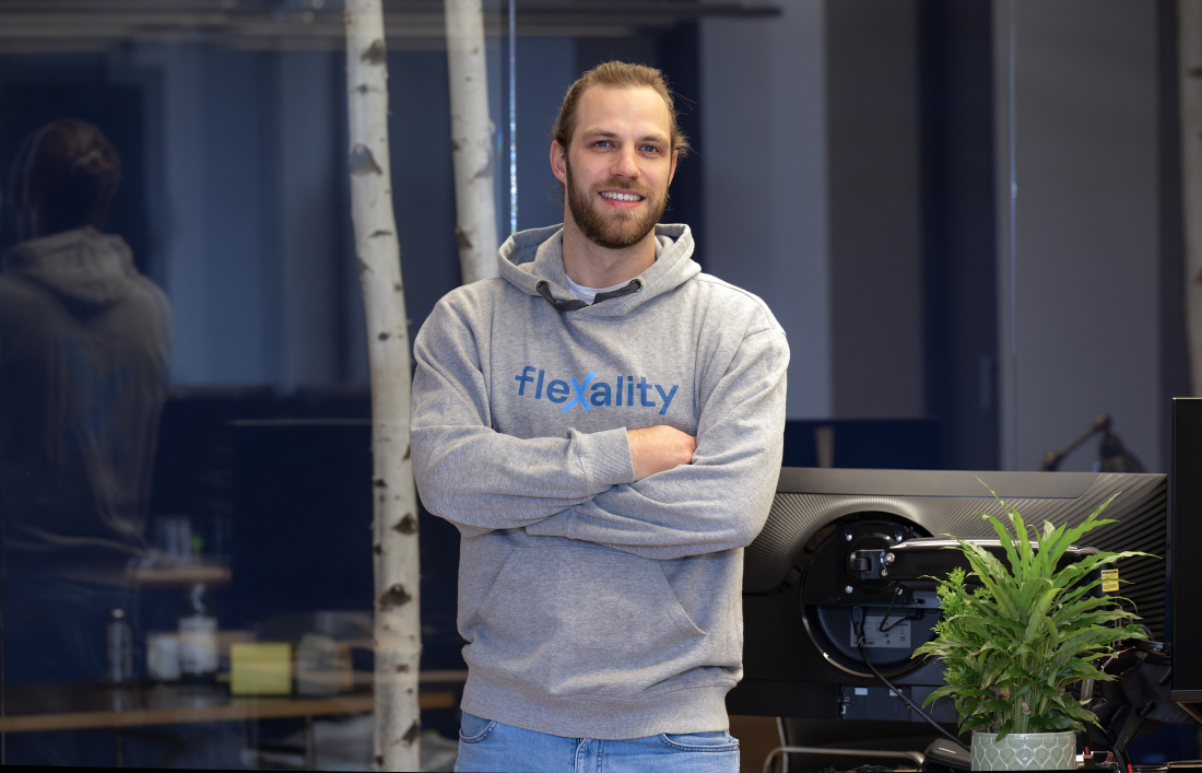 Dyke Wilke steht frontal zur Kamera und trägt einen Pullover mit der Aufschrift "flexality"