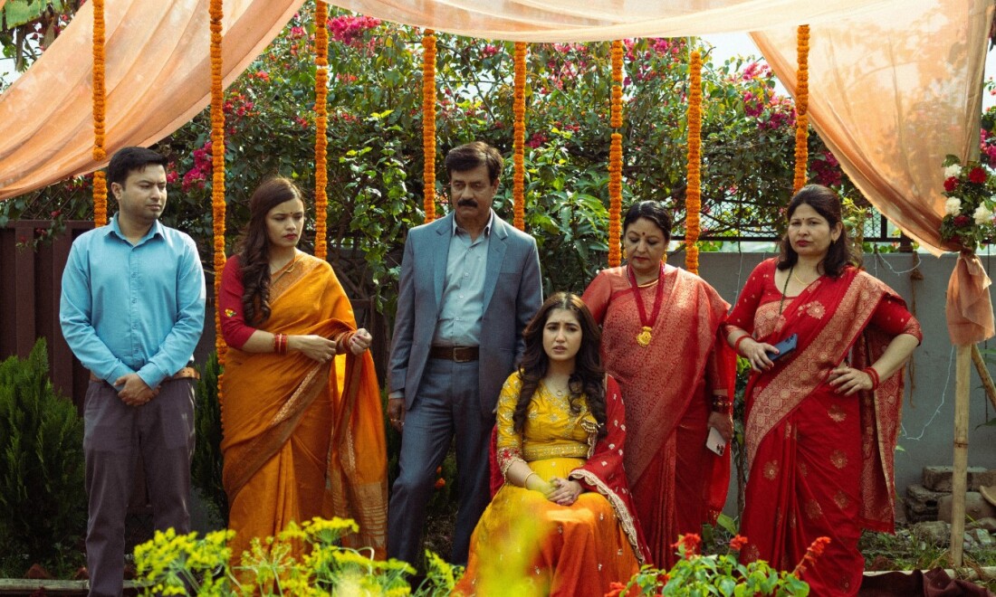 Eine indische Familie steht in festlicher Kleidung in einem Garten