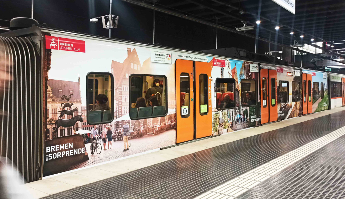 Man sieht ein Teil einer Metro an einem Gleis und auf der Metro ist Bremen-Werbung