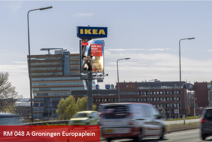 Man sieht eine Autobahn, auf der Autos fahren. Zentral in der Mitte ist ein Schild mit Bremen-Werbung und dadrüber ein Ikea-Schild. 