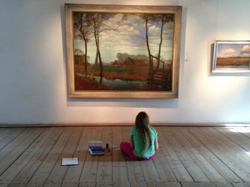 Mädchen sitzend vor Gemälde von Fritz Overbeck