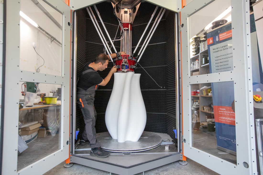 Menschen stehen mit einem 3D-Drucker in einer Garage