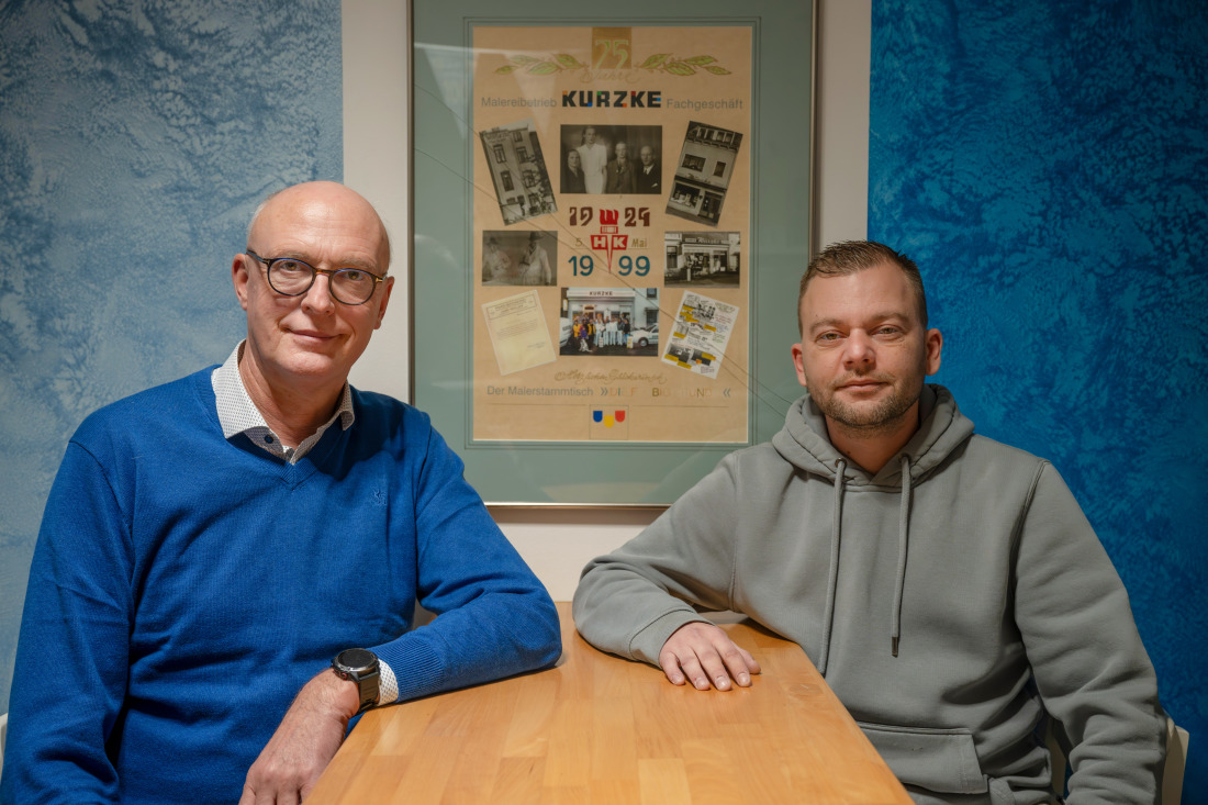 Zwei Männer sitzen am Tisch