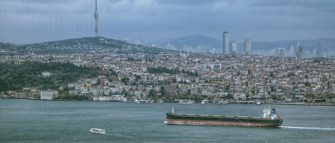 Schiff fährt vor einer Stadt entlang