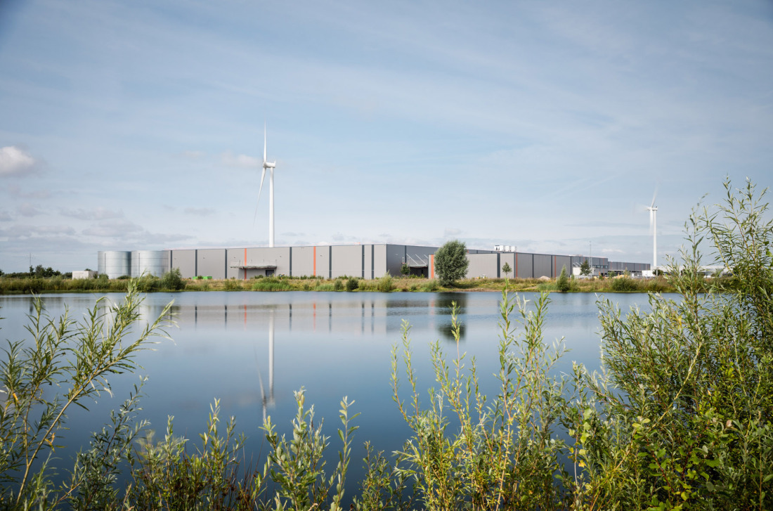 View of industrial buildings, a lake in the foreground